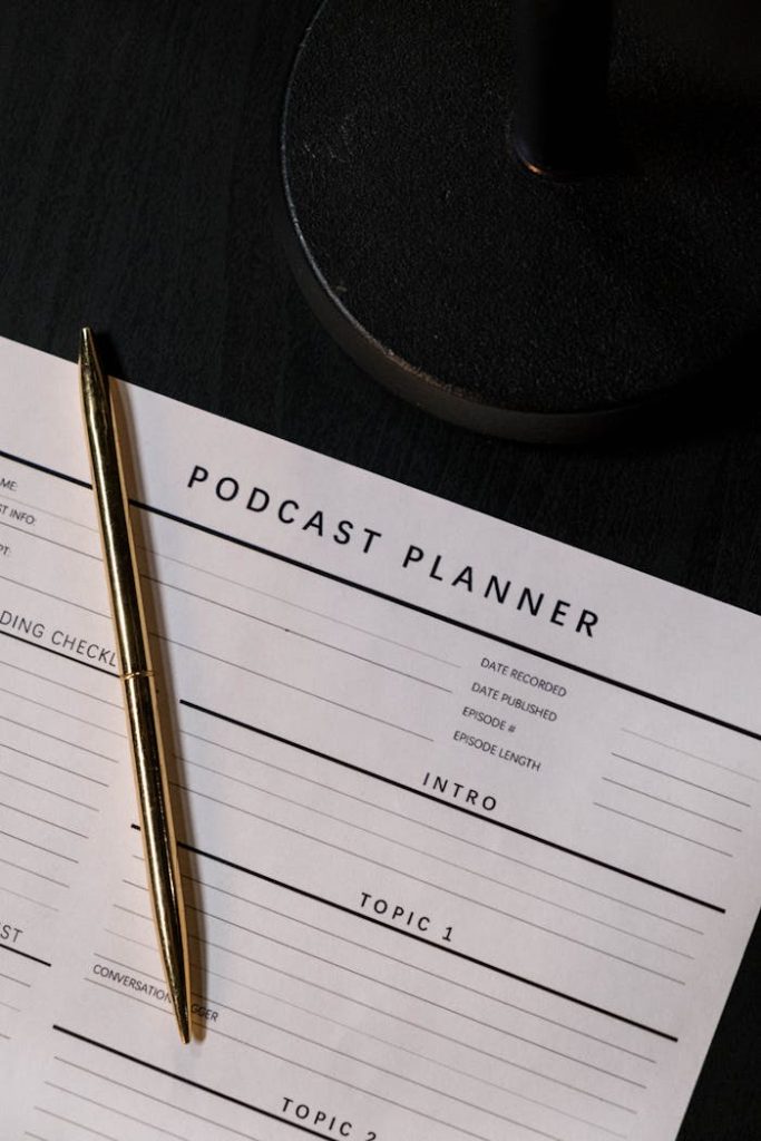 Vertical shot of a podcast planner and pen on a dark table, ideal for business and planning concepts.